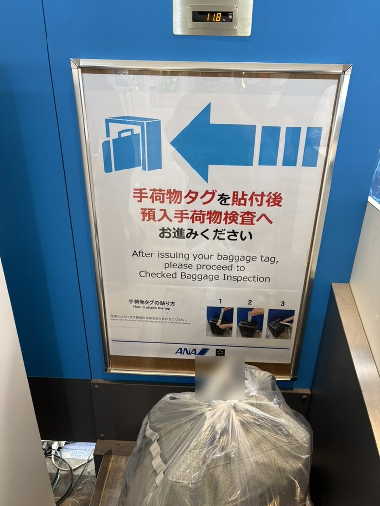 ANAの手荷物カウンターで荷物の重さを量っているところ（写真は25kgだった荷物とは別の荷物。表示は11.8kg）